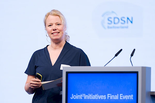ventfotograf Bern für Firmenanlässe – Professionelle Fotografie einer Referentin beim Joint Initiatives Final Event in der Eventfabrik Bern. Diskrete, hochwertige Eventfotografie, die die Dynamik und Professionalität deiner Business-Veranstaltung einfängt."